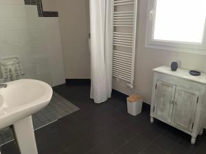 a bathroom with a sink and a shower curtain at LOGEMENT ENTIER Tilleul Suite in Fléac +5 photos