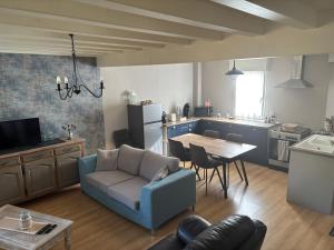 a living room with a blue couch and a table at LOGEMENT ENTIER Tilleul Suite in Fléac