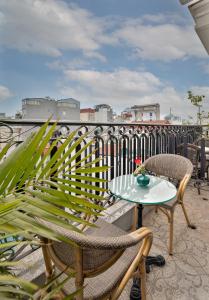 a patio with two chairs and a table on a balcony at Golden Legend Boutique Hotel in Hanoi