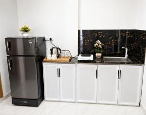 a kitchen with a black refrigerator and a sink at Bliss Stay in Katugastota +10 photos