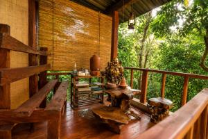 a porch of a house with benches and a table at Bliss Stay in Katugastota