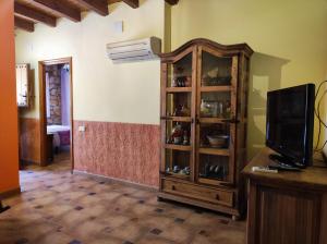 a living room with a tv and a wooden hutch at Casas Rurales Ribera de Salobre in Salobre