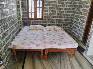 a small bed in a small room with a mattress at Harekrishna Nilayam in Vemalwāda