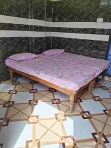 a mattress sitting on a wooden table with a chair at Harekrishna Nilayam in Vemalwāda