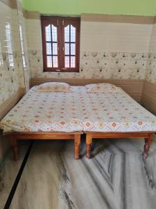 a bed sitting on the floor in a room at Harekrishna Nilayam in Vemalwāda