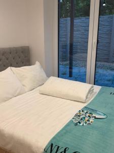 a bed with a blanket on it with a window at Apartament Venis ul Jodłowa in Opole