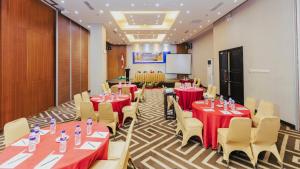 a conference room with tables and chairs and a podium at Continent CentrePoint Makassar in Pampang
