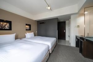 a hotel room with two beds and a bathroom at Hotel Vista Sapporo Odori in Sapporo +22 photos