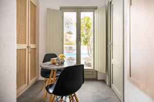 a dining room with a table and two chairs at Villa LuxL in Fira