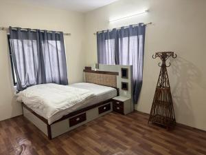 a bedroom with a bed with blue curtains and a tripod at Double tree hill side resort 2 in Burhānilkantha