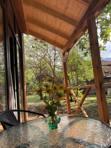 a glass table with a vase of flowers on a porch at Babitouli-2 in Niabauri