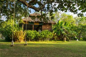 a house with a swing in front of a yard at Rabbit Bungalow in Ko Phayam