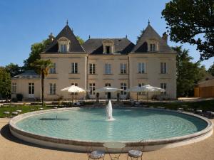 a fountain in front of a large building at Château du Portereau in Vertou