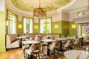 a restaurant with tables and chairs and a chandelier at Château du Portereau in Vertou