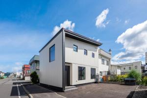 a white house with a black roof on a street at S - Vacation STAY 20201 in Asahikawa