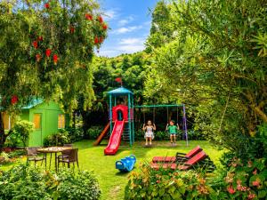 two children playing on a playground in a yard at Vikram Vintage Inn in Nainital