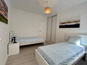 a bedroom with two beds and a painting on the wall at Casa Miami Alcalà in Alcalá