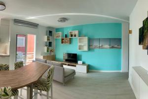 a living room with a table and a blue wall at Casa Miami Alcalà in Alcalá