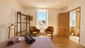 a bedroom with a bed with two chairs and a window at Le Bellevue in Excénevex +33 photos