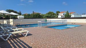 a swimming pool with lounge chairs and a swimming pool at Nissi Golden Sands Paradi in Ayia Napa