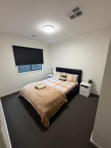 a bedroom with a large bed with a flat screen tv at Wodonga House Huon hill in Bandiana
