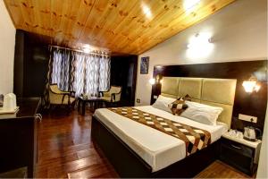 a bedroom with a large bed with a wooden ceiling at New Daffodil Classic Manali in Manāli +28 photos