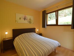 a bedroom with a bed with two night stands and two windows at Cottage in Aywaille with Garden in Aywaille