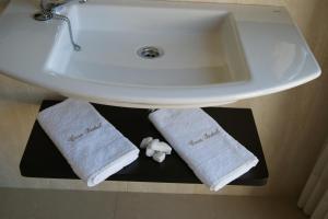 a bathroom sink with towels on a shelf under it at Hostal Casa Isabel in Portonovo