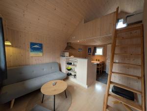 a living room with a couch and a table at Tornby Strand Camping Cottages in Hirtshals
