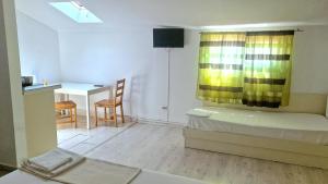 a room with a bed and a desk and a kitchen at Titulescu Apartments in Bucharest