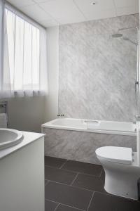 a bathroom with a tub and a toilet and a sink at Cardiff Bute Terrace Hotel By Belvilla in Cardiff +23 photos