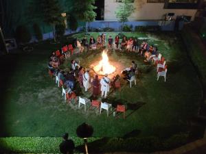 a group of people sitting around a fire at New Daffodil Classic Manali in Manāli