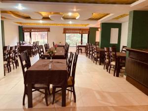 a dining room with wooden tables and chairs at New Daffodil Classic Manali in Manāli