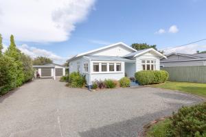 a white house with a driveway at Harrison House in Featherston