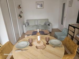 a dining room table with a bottle of wine on it at Studio 2 personnes in Cucq
