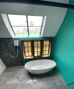 a bathroom with a large white tub in a room with windows at Peace in Ranong in Ban Cho +69 photos