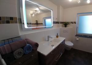 a bathroom with a sink and a large mirror at Ferienhaus Bumblebee im Allgäu in Eggenthal +13 photos