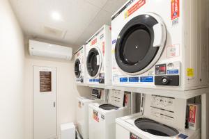 a laundry room with three washers and a dryer at NOVI Dotonbori in Osaka
