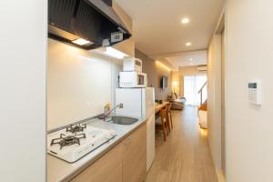 a kitchen with a sink and a white refrigerator at NOVI Dotonbori in Osaka