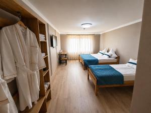 a hotel room with two beds and a closet at DEMAL Mountain Resort in Alamedin