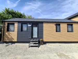 a tiny house on a gravel parking lot at Mobilheim Bumblebee im Allgäu in Oberegg