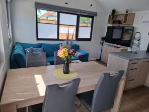 a dining room table with a vase of flowers on it at Mobilheim Bumblebee im Allgäu in Oberegg