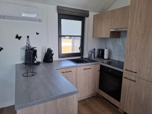 a kitchen with a counter and a sink and a window at Mobilheim Bumblebee im Allgäu in Oberegg +5 photos