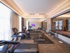 a gym with a lot of exercise equipment in a room at Mercure Xi'an Qujiang in Xi'an