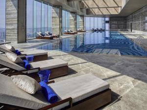 a large swimming pool with blue vases in a building at Pullman Huizhou Kaisa in Huizhou