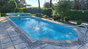 a swimming pool with a metal rail in a yard at Chalet del Daniel en La Calabaza in Aranda de Duero