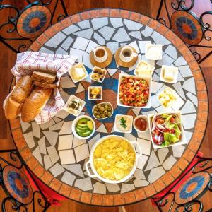 a table with breakfast foods on a mosaic table at BeLev Odem in Odem