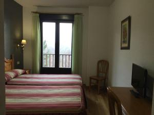 a hotel room with a bed and a window at Hotel Cinco Castaños in Candelario