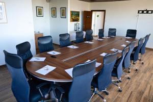 a conference room with a large wooden table and chairs at Lavender Boutique Hotel in Ramallah