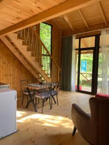 a living room with a table and chairs and a staircase at Babitouli-1 in Niabauri